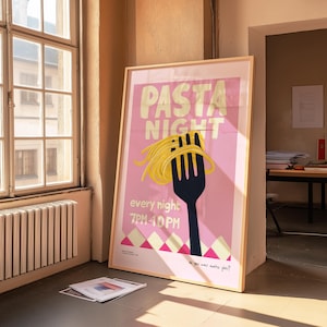 Puede incluir: Un póster rosa con el texto "PASTA NIGHT" en letras doradas. Un tenedor con una gran porción de pasta se muestra en el centro del póster. El texto "every night 7PM-10PM" está debajo del tenedor. El póster está enmarcado en madera.