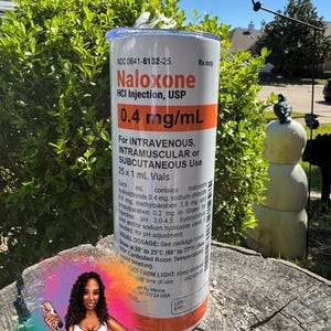 May include: A cylindrical tumbler featuring a white label design with orange accents, mimicking a Naloxone HCl Injection 0.4 mg/mL medication vial. The text includes dosage instructions, ingredients, and storage details, with a clear lid on top.