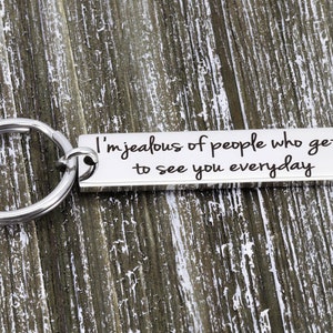May include: Silver keychain with a rectangular tag that reads "I'm jealous of people who get to see you everyday".