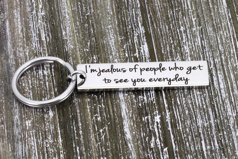 May include: Silver keychain with a rectangular tag that reads "I'm jealous of people who get to see you everyday".