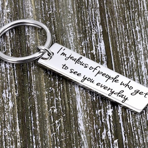 May include: Silver keychain with a rectangular tag that reads "I'm jealous of people who get to see you everyday".