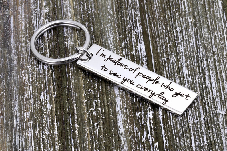 May include: Silver keychain with a rectangular tag that reads "I'm jealous of people who get to see you everyday".