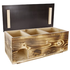 Può includere: Una casetta di legno per ricci con un coperchio incernierato e tre scomparti. La casetta è realizzata in legno naturale con una finitura bruciata. La parte anteriore della casetta ha una piccola apertura per consentire al riccio di entrare.