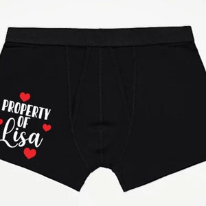 May include: Black boxer shorts with the text "PROPERTY OF Lisa" in white with red hearts.