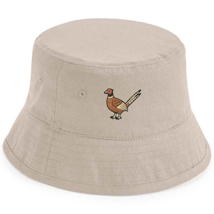 May include: A beige bucket hat with a brown pheasant embroidered on the front.