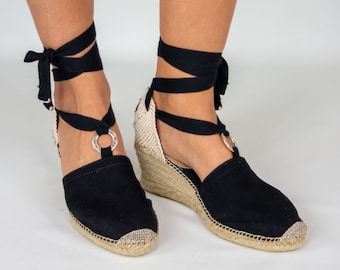 Espadrillas con zeppa alta realizzate a mano in cotone nero, con anello in metallo e nastri neri.