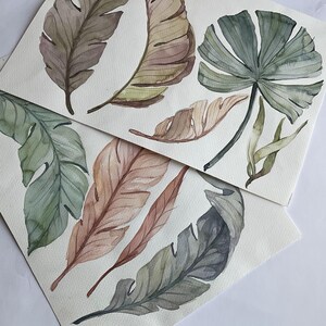 May include: Two sheets of paper with watercolor paintings of tropical leaves. The leaves are painted in shades of green, brown, and beige.