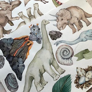 May include: Watercolour illustration of various dinosaurs, including a triceratops, a brachiosaurus, and a pterodactyl. The illustration also includes a volcano, a nest of eggs, and leaves.