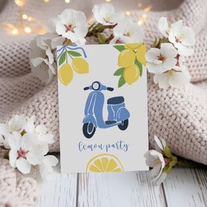 May include: A greeting card with a light blue scooter illustration, yellow lemons, and the words "lemon party". The card is decorated with white flowers and rests on a knitted blanket.