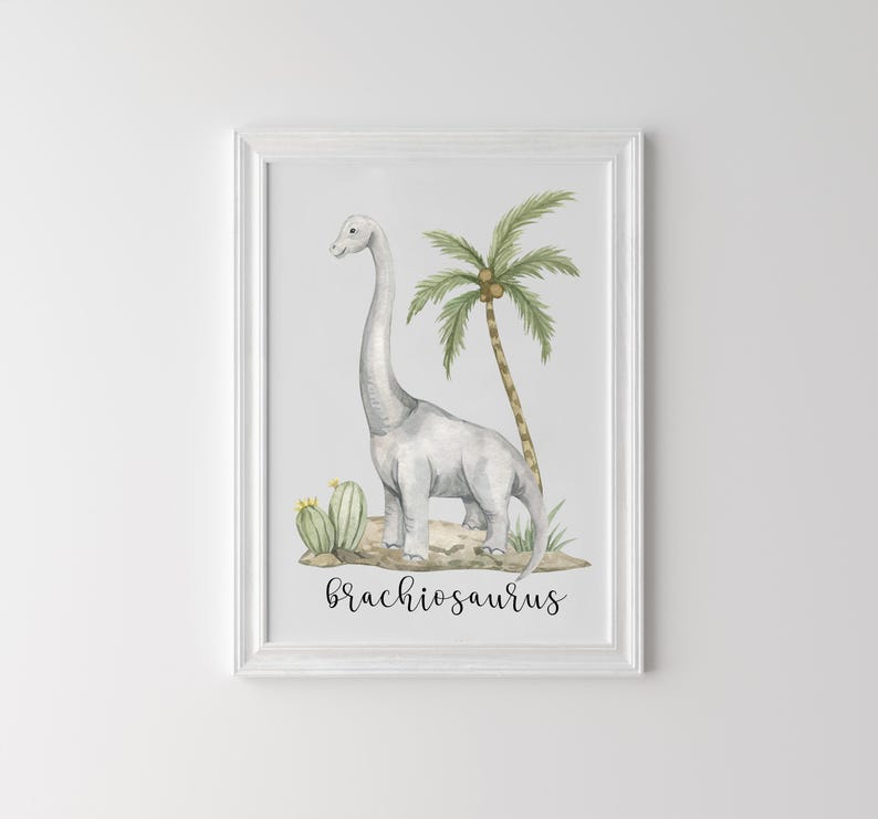 May include: Watercolor print of a Brachiosaurus dinosaur in a white frame. The artwork features a gray dinosaur, a palm tree, and cacti. The word "Brachiosaurus" is written in a cursive font at the bottom of the image.