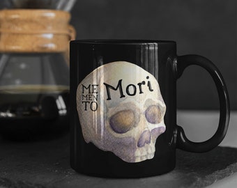 May include: Black coffee mug with a white skull graphic and the text "Memento Mori".