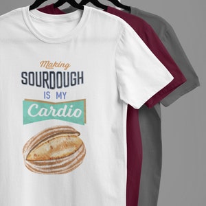 May include: White t-shirt with the text "Making sourdough is my cardio" and a graphic of a loaf of sourdough bread.