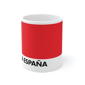 May include: White ceramic mug with a red band and black text that reads "VUELTA A ESPA&Ntilde;A MAILLOT ROSA".
