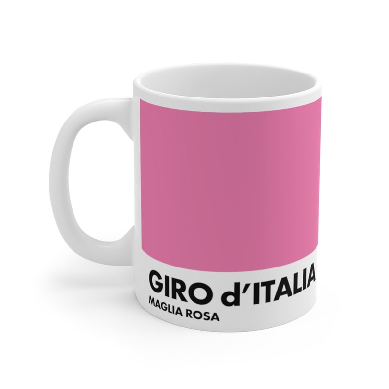 May include: White ceramic mug with a pink design and the text "GIRO d'ITALIA MAGLIA ROSA".