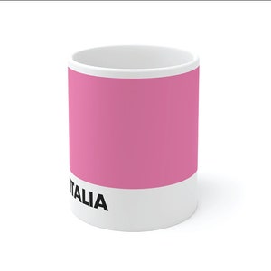 May include: A white ceramic mug with a pink stripe and the text "GIRO d'ITALIA MAGLIA ROSA" printed on the front.