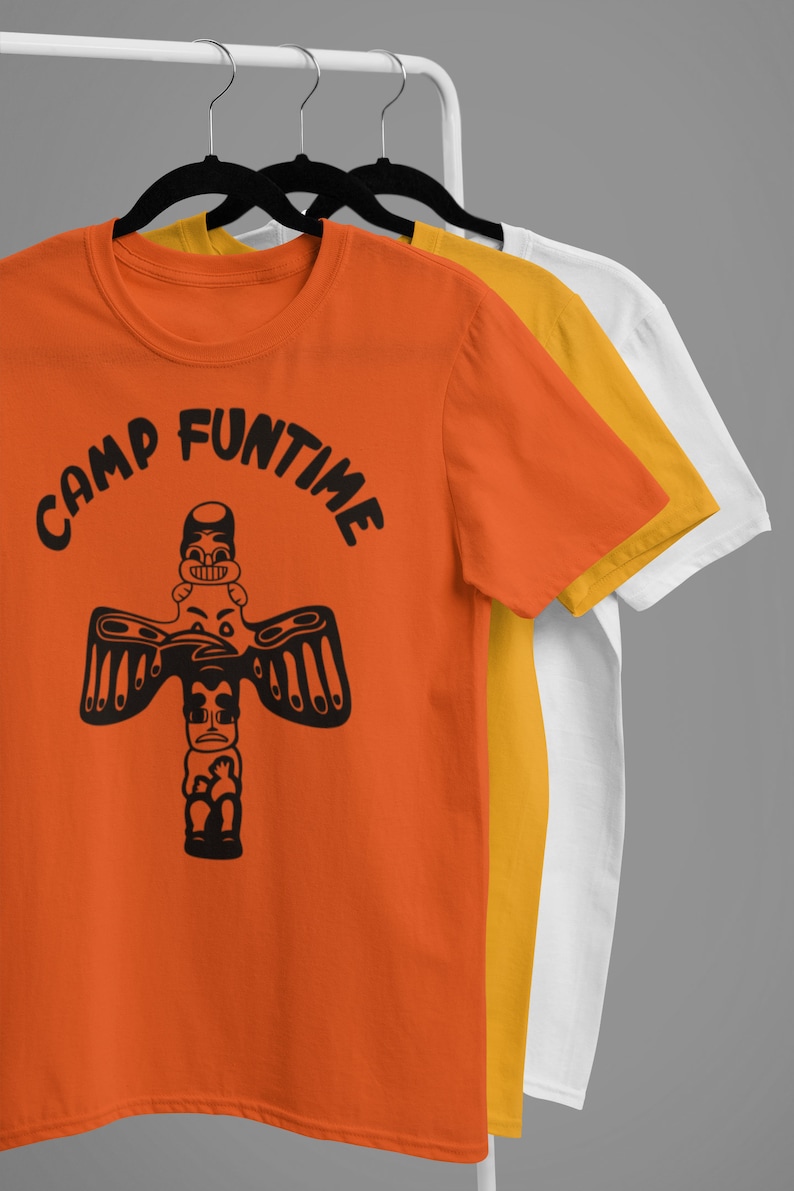 May include: Orange, yellow, and white t-shirts with a black graphic of a totem pole with the text "Camp Funtime" on the orange shirt.
