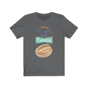 May include: A dark gray t-shirt with the text "Making sourdough is my cardio" in a vintage style font. A watercolor illustration of a sourdough loaf is below the text.