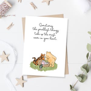 Puede incluir: Una tarjeta de felicitación con un sobre marrón. La tarjeta presenta una ilustración de un tigre, un oso y un cerdito. El texto de la tarjeta dice: "A veces, las cosas más pequeñas ocupan la mayor parte de tu corazón."