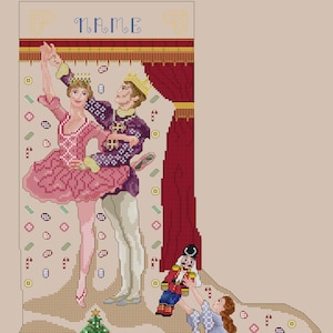 Puede incluir: Una media de Navidad con temática de Cascanueces. La media presenta una escena de una bailarina y su príncipe bailando en el escenario, con un muñeco Cascanueces y una niña observando desde abajo. La media está decorada con bastones de caramelo, galletas de jengibre y otros elementos festivos.