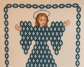 May include: Cross-stitch artwork of an angel with outstretched arms. The angel's dress and wings are a pattern of blue and white diamonds. The angel has brown hair and a halo. The artwork is framed with a blue border.