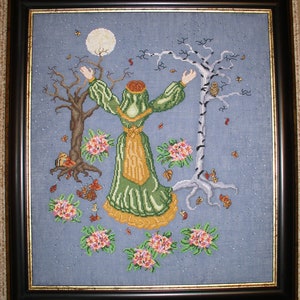 May include: A cross-stitch embroidery depicting a woman in a green and gold dress standing between two trees. The woman is reaching up towards a full moon. The trees are bare and have fallen leaves around them. There are small flowers scattered around the woman and trees.
