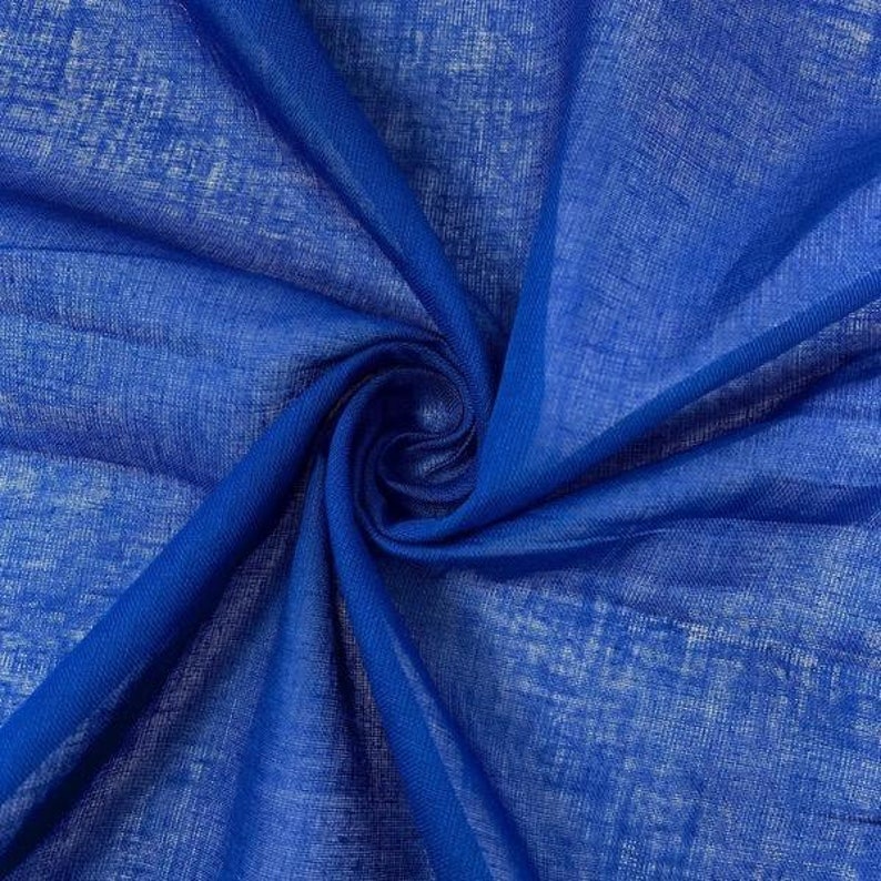May include: A close-up of a royal blue fabric with a textured, slightly rough surface. The fabric is folded and draped, showcasing its soft, flowing texture.