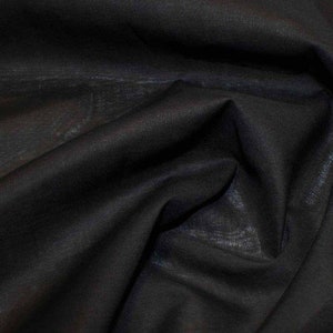 May include: Black fabric with a smooth, slightly textured surface. The fabric is folded and draped, showing its soft and flowing nature.