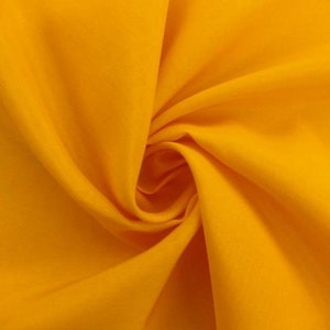 May include: A bright yellow fabric with a smooth texture. The fabric is folded and draped, creating a soft, flowing look.