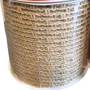 May include: A roll of natural brown hessian ribbon with a woven texture. The ribbon is wound around a white cardboard spool.