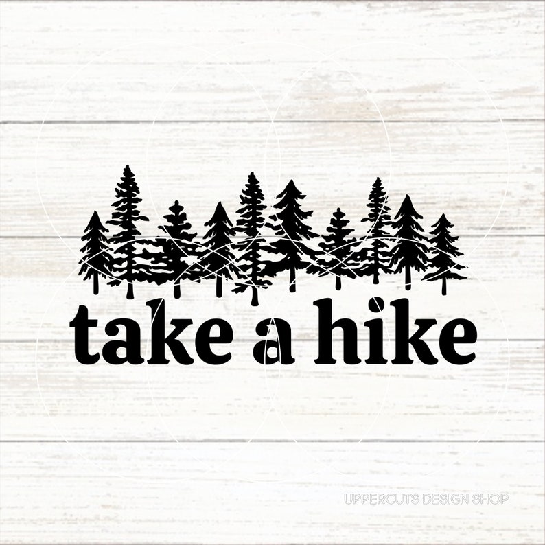 Op de afbeelding: Zwart-witte silhouet van een bos met de tekst "take a hike" eronder. De afbeelding is op een witte houten achtergrond.