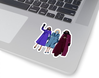 May include: Three women wearing face masks and coats stand together. The woman on the left is wearing a purple coat, the woman in the middle is wearing a blue coat, and the woman on the right is wearing a burgundy coat.
