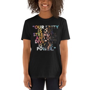 May include: Black t-shirt with a colorful graphic print that reads "OUR UNITY IS OUR STRENGTH, AND OUR DIVERSITY IS OUR POWER."