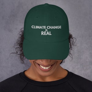 May include: A dark green baseball cap with white embroidered text that reads "Climate Change Is Real".