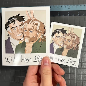 Può includere: Due stampe in stile polaroid con un'illustrazione di due uomini. Uno indossa occhiali e un abito, l'altro una camicia verde e la barba. Il testo "Will + Hen 198" e "Will + Hen 1981" è scritto sulle stampe.