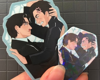 May include: Two black and white illustrated men in suits are facing each other. The man on the left is holding the man on the right's collar. The man on the right has a red angry mark on his forehead. The background is a blue and white pattern.