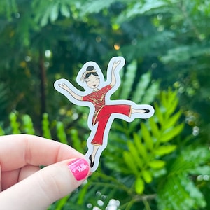 May include: A sticker featuring a cartoon illustration of a woman in a red and gold Chinese dress, with her arms outstretched and legs in a dance pose.