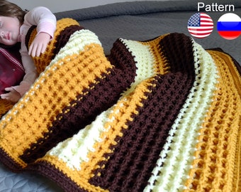 May include: A crocheted blanket with stripes of brown, yellow, and white. The blanket is made with a waffle stitch pattern.