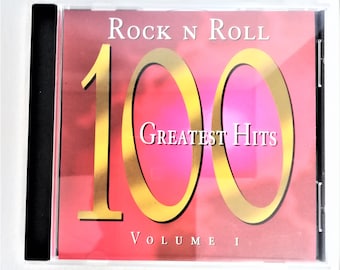 May include: A CD case with a pink and gold cover. The text reads "Rock N Roll 100 Greatest Hits Volume I." The number "100" is in gold, with the words "Greatest Hits" in white. The case is in a clear plastic jewel case.