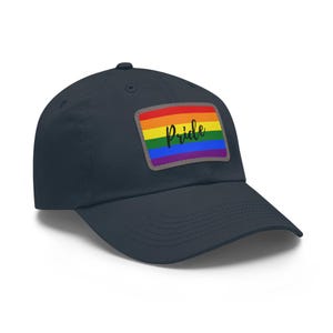 May include: A navy blue baseball cap with a rainbow pride flag patch that says "Pride" in black lettering.