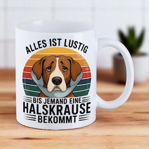 Könnte beinhalten: Weiße Keramik-Tasse mit einem Cartoon-Hund, der einen Halskragen trägt, vor einem Sonnenuntergangsdesign mit deutschem Text. Der Text lautet "Alles ist lustig bis jemand eine Halskrause bekommt", was übersetzt "Alles ist lustig, bis jemand einen Halskragen bekommt" bedeutet.
