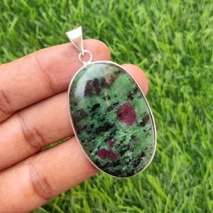 Puede incluir: Colgante ovalado de piedra preciosa verde y rosa con engaste de plata.