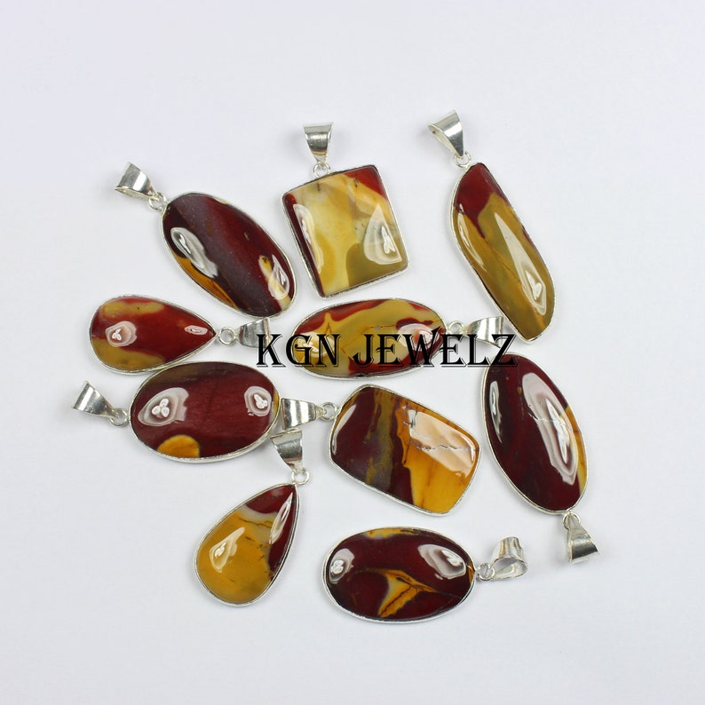 May include: Assortment of nine silver pendant charms featuring red, brown, and yellow jasper stones. The stones are all different shapes and sizes, and they are set in silver.