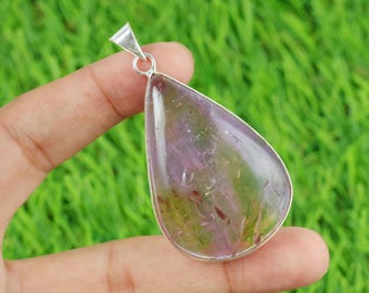 May include: A teardrop-shaped pendant with a silver-colored metal frame. The pendant features a translucent, polished stone with shades of purple, green, and red. The stone is suspended from a silver loop and bail.