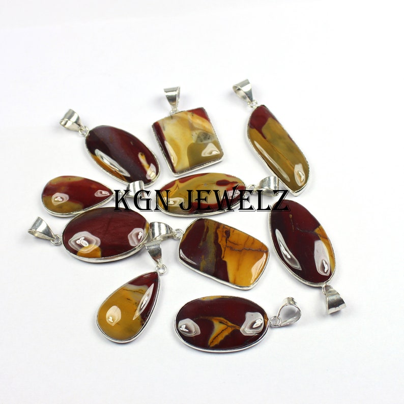 May include: A collection of nine silver pendant necklaces with red, brown, and yellow jasper stones. The stones are all different shapes and sizes, and they are set in silver.