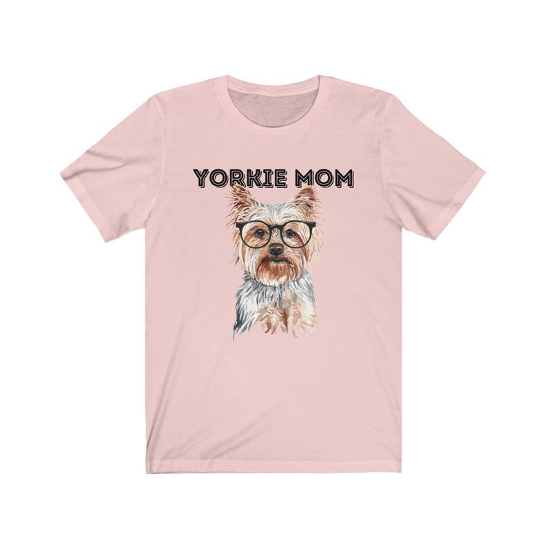 May include: Pink t-shirt with the text "Yorkie Mom" and a watercolor illustration of a Yorkshire Terrier wearing glasses.