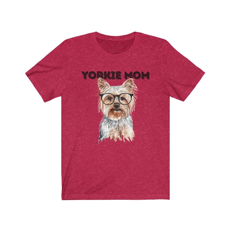 May include: Red short-sleeved t-shirt with the text "Yorkie Mom" in black lettering and a watercolor illustration of a Yorkshire Terrier wearing glasses.