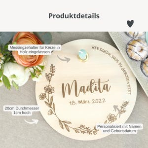 May include: A wooden round plaque with a floral design and the name "Madita" engraved on it. The plaque also includes the date "18. M&auml;rz 2022" and the text "Wie sch&ouml;n, dass du geboren bist". The plaque is 20 inches in diameter and 1 inch high.