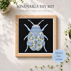 May include: A Kinusaiga DIY kit featuring a framed fabric art piece of a beetle. The beetle is constructed from light blue and white fabric with floral and gingham patterns, set against a solid black background within a light wood frame.