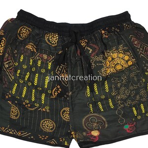 May include: Black shorts with an elasticated waistband and drawstring. The shorts have a patchwork design with gold and maroon patterns, including floral and geometric motifs. The text "jannatcreation" is visible.