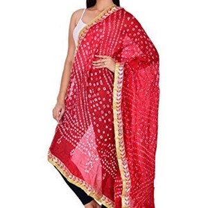 May include: A vibrant red dupatta with a detailed white dot pattern and gold trim. The scarf is draped over the shoulder, showcasing its intricate design and flowing fabric. The dupatta adds a touch of elegance and color.